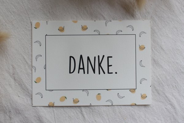 Eine Gutscheinkarte mit dem Wort "Danke" liegt auf einer Decke